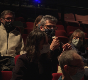 An audience member takes the microphone in a theatre